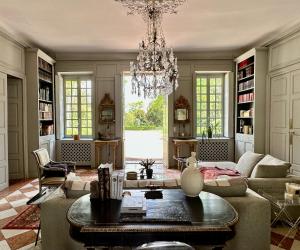 a living room with a couch and a chandelier at Côté Park in Givry