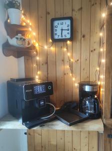 a clock on a wall with a coffee maker and a microwave at Szafran Home Spa in Korbielów