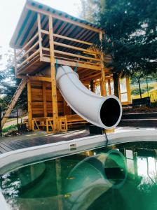 a slide in front of a house next to a swimming pool at Szafran Home Spa in Korbielów