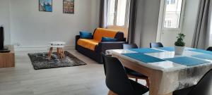 a living room with a table and a couch at Appartement Entre terre et mer in Dunkerque