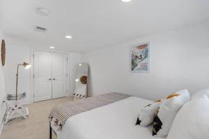 a white bedroom with a large white bed with pillows at Stone's Throw from Capitol Hill Free Parking in Washington, D.C.