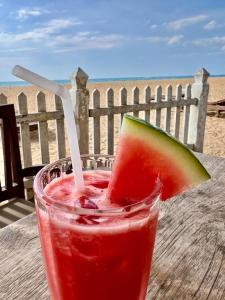 een drankje zittend op een tafel met een stuk watermeloen bij Luxury Beach Condo Dehiwala Mt Lavinia in Watumulla