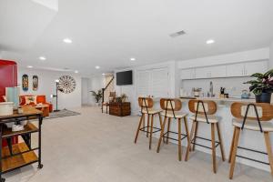 a kitchen with white cabinets and bar stools at Stone's Throw from Capitol Hill Free Parking in Washington, D.C.