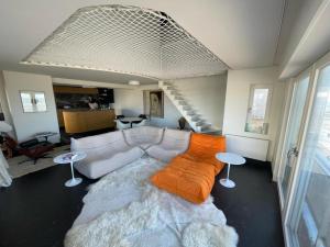 uma sala de estar com um sofá branco e uma escada em Vista del Mar Sixties em Koksijde