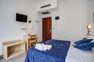 a bedroom with a bed with a blue comforter at Hotel Tiziana in Rimini