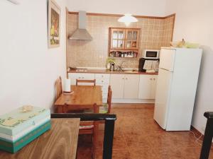 cocina con mesa y nevera blanca en Casa Olga en Caleta de Sebo