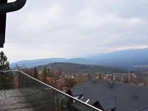 a view of a house with mountains in the background at VacationClub - Górna Resorts Apartament 2.68 in Szklarska Poręba