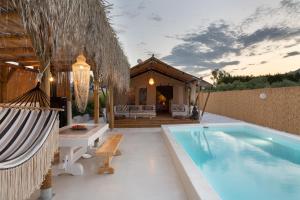 a backyard with a swimming pool and a house at NOMAD GLAMPING in Schinias
