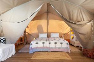a bedroom with a bed in a tent at NOMAD GLAMPING in Schinias