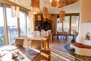 a restaurant with tables and chairs and large windows at Harmonia Mundi in Vlaha