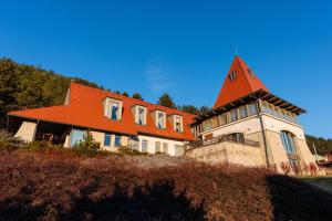 ein großes Haus mit orangefarbenem Dach auf einem Hügel in der Unterkunft Harmonia Mundi in Vlaha