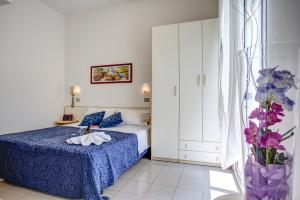 a bedroom with a bed and a vase of flowers at Hotel Tiziana in Rimini