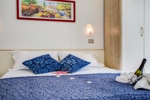 a bedroom with a bed with two blue pillows at Hotel Tiziana in Rimini