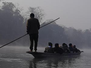 un homme qui monte à bord d'un bateau avec un groupe de personnes dans l'établissement Crocodile Safari Camp, à Chitwan