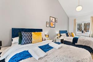 a bedroom with two beds with blue and white at Unique Cambridgeshire Gem in Fulbourn