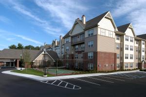 a large building with a tennis court in a parking lot at Residence Inn by Marriott Saratoga Springs in Saratoga Springs