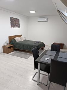 a bedroom with a bed and a table and chairs at Mira apartman in Debrecen