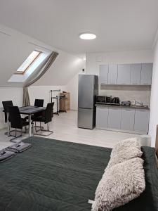 a living room with a table and a kitchen at Mira apartman in Debrecen