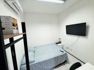een slaapkamer met een bed en een flatscreen-tv bij Mini Ap no derby com Garagem in Sobral