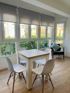 una mesa y sillas en una habitación con ventanas en Estudio nuevo en Benicarló, en Benicarló