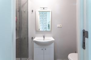 Van Lerius room في أنتويرب: حمام أبيض مع حوض ومرآة