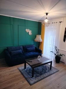 - un salon avec un canapé bleu et une table basse dans l'établissement Apartamenty Leśna Osiem, à Jeżów Sudecki