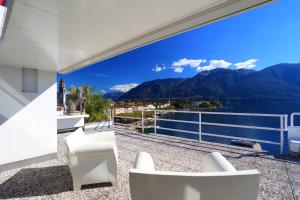 een balkon met uitzicht op het water en de bergen bij art Ascona Design Attico in Ascona