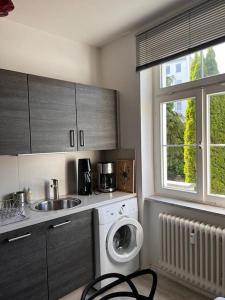 a kitchen with a washing machine and a sink at seeglueck SEELIEBE Stadtlage in Konstanz