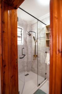 y baño con ducha y puerta de cristal. en Cadenrockvilla - Furnished 3 bedroom villa with pool, en Ruiru