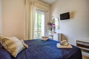 a bedroom with a bed with two towels on it at Hotel Tiziana in Rimini