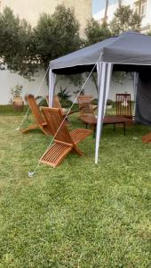 un groupe de chaises sous une tente dans l'herbe dans l'établissement Appartement spacieux, Résidence Les 5 étoiles, Bizerte, à Zarzouna