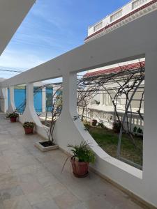 un bâtiment blanc avec des plantes en pot sur une terrasse dans l'établissement Appartement spacieux, Résidence Les 5 étoiles, Bizerte, à Zarzouna