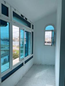 a room with windows and a view of the ocean at Appartement spacieux, Résidence Les 5 étoiles, Bizerte in Zarzouna