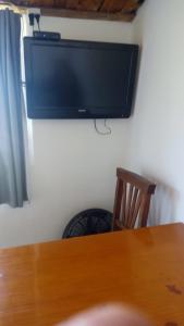 ein Flachbildfernseher, der mit einem Holztisch an der Wand hängt in der Unterkunft Alojamiento de Serranía in Villa Rumipal + 16 Fotos