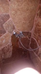 a water hose attached to a stone wall at Alojamiento de Serranía in Villa Rumipal +16 photos