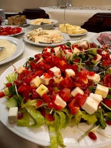 a plate of salad with cheese and vegetables on a table at APARTAMENTY Kolonia Leśna in Wünschelburg