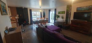 a living room with a couch and a tv at 2 vraies chambres privées au calme dans villa de campagne plain-pied 105m2 avec piscine à Montfaucon in Montfaucon