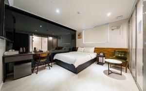 Habitación de hotel con cama y escritorio en Mnlucky Hotel, en Seúl