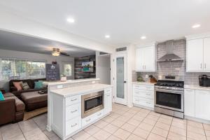 a kitchen with white cabinets and a living room at Cozy Tempe Casa with Heated Pool 5 Minutes to ASU in Tempe