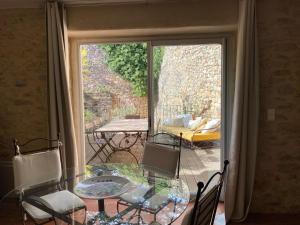 een glazen tafel en stoelen in een kamer met een patio bij Le mas d'Orsan in Orsan