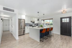 a kitchen with white cabinets and an island with orange chairs at Crown Azul - Old Town 2 Primary's New Pool Spa BBQ in Scottsdale +36 photos