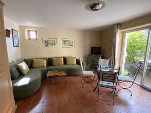 een woonkamer met een groene bank en stoelen bij Le mas d'Orsan in Orsan