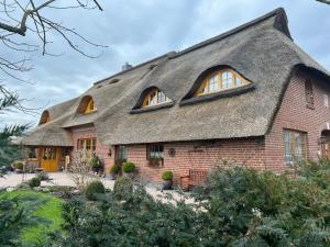 a thatch roofed house with a thatched roof at Gästehaus-Erbst in Loxstedt