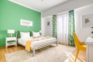 a bedroom with a bed with a green wall at SMG Boutique Apartments in Athens