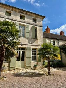 uma casa com uma palmeira em frente em Côté Park em Givry