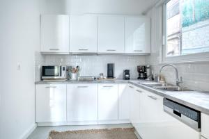 a white kitchen with white cabinets and a sink at SMG Boutique Apartments in Athens