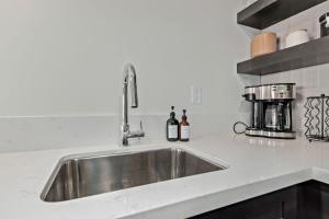 a stainless steel sink in a white kitchen at LUX at Craftsman - Heart of Old Town Studio 1 in Scottsdale +16 photos