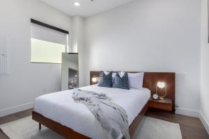 ein Schlafzimmer mit einem großen Bett mit weißer Bettwäsche und Kissen in der Unterkunft The LUX at Craftsman - Old Town Penthouse 1 in Scottsdale