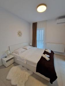 a bedroom with a bed with two towels on it at Cora Apartment in Baia Mare