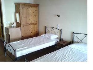 2 camas individuais num quarto com um armário em Alykes 4 Seasons em Alykes